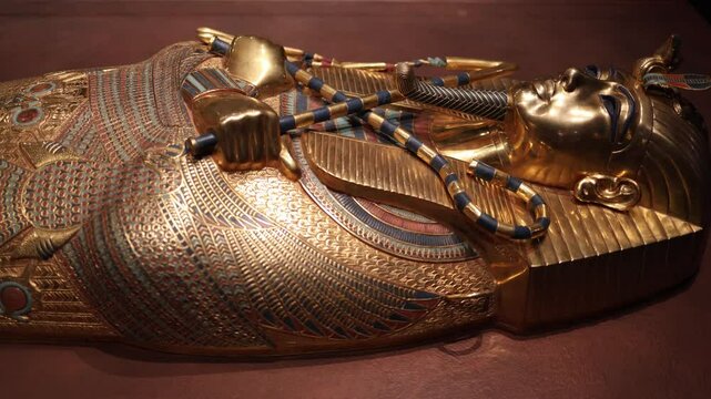 The golden sarcophagus of Pharaoh Tutankhamun, richly adorned with lapis lazuli, carnelian, and intricate engravings. This artifact symbolizes the grandeur and sacred rituals of ancient Egypt.