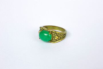 Golden ring adorned with beautiful green gems isolated on white background, accessories.
