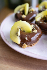 Donut de cubierta de chocolate y kiwi para el desayuno. 