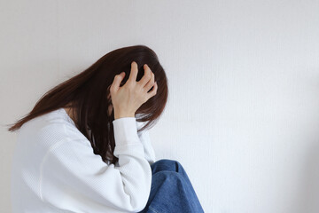 頭を抱える女性　悩みイメージ
