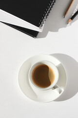 Business Office Desk Flatlay with Cup of Coffee, Notebooks, Graphite Pencils on White Background.	