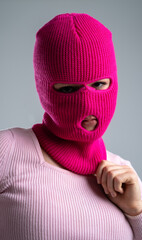 Woman in Pink Balaclava posing in the studio against a gray background