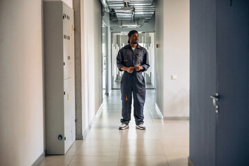 Fototapeta premium In the corridor. Repairman is indoors in the modern office