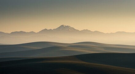 Obraz premium Rolling Hills Landscape with Distant Mountain Peak Under a Golden Sky