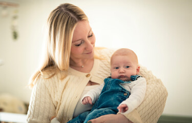 Cute small 1 month baby boy at home. Mother with little newborn infant.