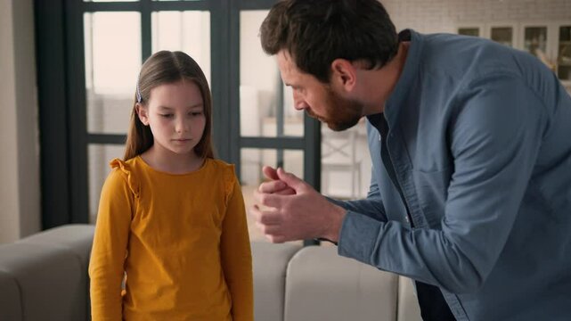 Angry stressed irritated Caucasian guy scold anxious rebellious kid little child schoolgirl man dad male scream at daughter girl at home argument father speaking parent shouting family quarrel problem