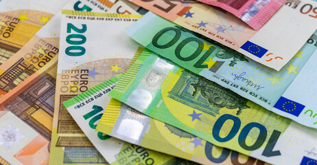 Euro banknotes, various denominations, scattered, top view.