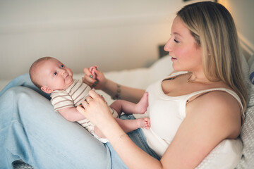 Cute small 1 month baby boy at home. Mother with little newborn infant.