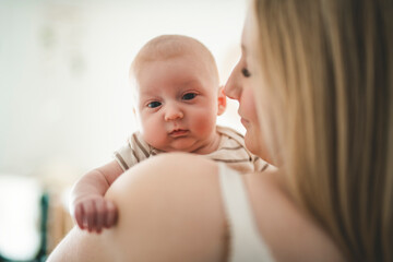 Cute small 1 month baby boy at home. Mother with little newborn infant.