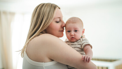 Cute small 1 month baby boy at home. Mother with little newborn infant.