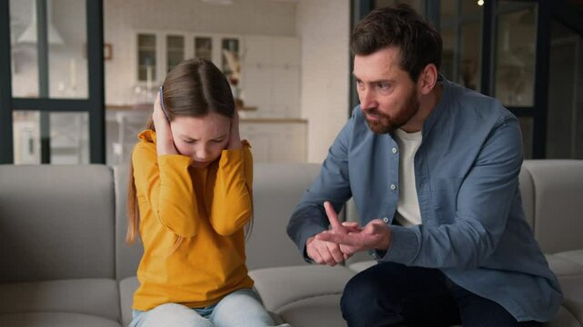 Anxious stressed Caucasian girl schoolgirl daughter cover ears furious dad man guy yell at home family domestic abuse annoyed father male arguing parent scream at scared child kid misbehavior crisis