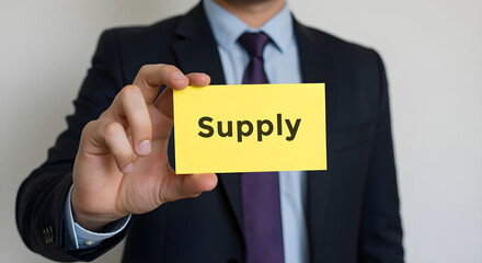 Businessman is holding a card on which is written supply, Business, Corporate, Office, Teamwork, Finance, Technology, Meeting, Success, Marketing, Strategy.