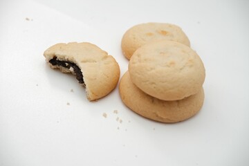 Stack of soft butter cookies with a chocolate filling, isolated on white background