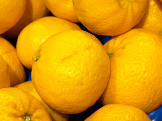 Fresh juicy oranges in a pile displaying vibrant yellow color