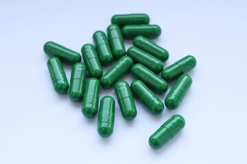 green pills on white background