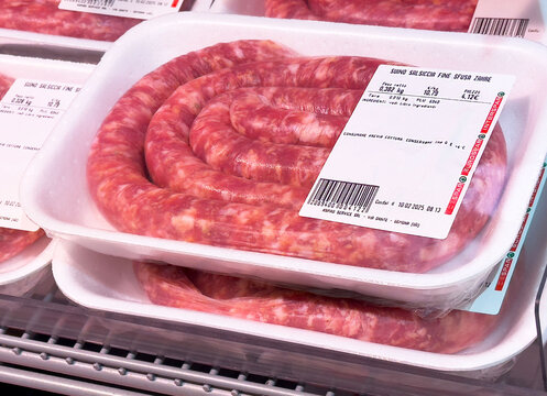 Fresh spiral sausages in supermarket packaging display