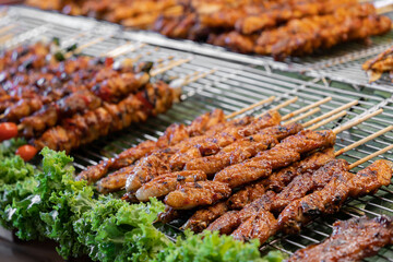 A variety of barbecue meat skewers are being sold at the food stall.