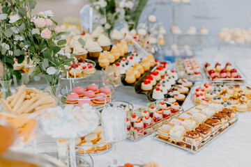 Sweet snacks for wedding guests, wedding hall wedding day, table with sweets and cakes