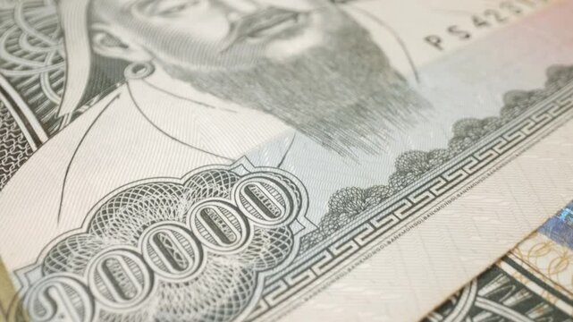 Macro shot of a Mongolian 10,000-tugrik banknote with a sliding motion.