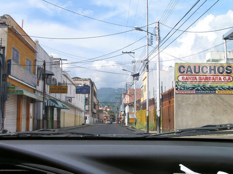 Exploring the streets of Maracay, Venezuela with a view of nearby mountains and local businesses in clear weather