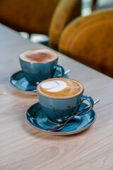 Cup with hot cappuccino with foam on the table. coffee art.