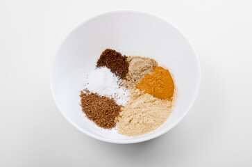 Spices in a bowl: ginger, turmeric, cinnamon, pepper, cloves