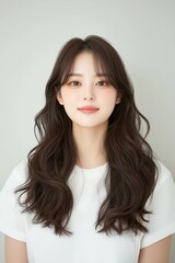 Fototapeta premium Portrait of a Smiling Woman with Long Flowing Hair in a White Shirt