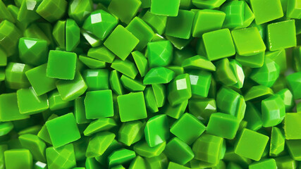 Macro shot of glossy green diamond painting drills arranged in a pile.