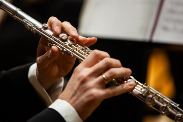 Close-up of musician's hands playing flute