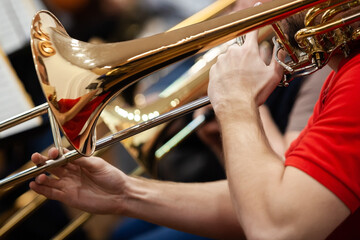 Close-up of musician's hands playing trombone