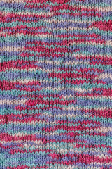 Fototapeta premium A simple knitting pattern made of melange multi-colored yarn in lilac pink and turquoise shades. Spring mood. Handicraft as a way of self-expression.
