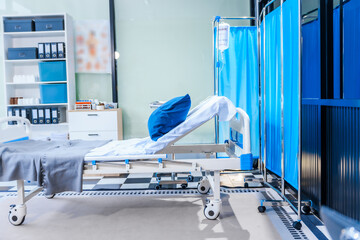 An empty medical bed sits in a glass hospital room, bathed in daylight. Equipped with adjustable features, it awaits the next patient, essential medical equipment for emergency and critical care.