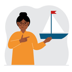 A woman holds a sailing yacht in his hand. Concepts of freedom, hope and big plans. Hobby, sport or business.