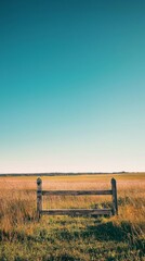 Tranquil Meadow Scene with Wooden Fence and Clear Blue Sky