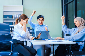 Middle-aged Asian man and Muslim woman in hijab sit across from each other in business meeting. They review report documents, discussing strategies and making decisions, successful, professional.