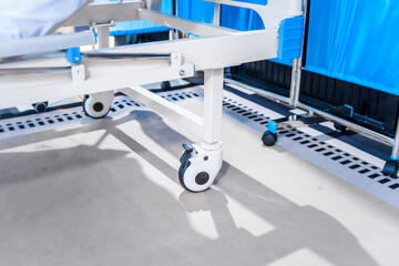 An empty medical bed sits in a glass hospital room, bathed in daylight. Equipped with adjustable features, it awaits the next patient, essential medical equipment for emergency and critical care.