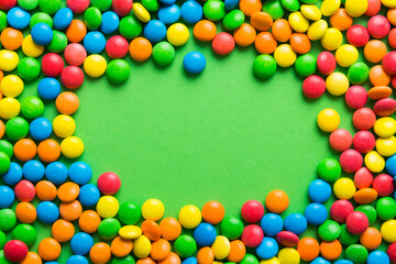 Mixed collection of colorful candy, on colored background. Flat lay, top view. frame of colorful chocolate coated candy