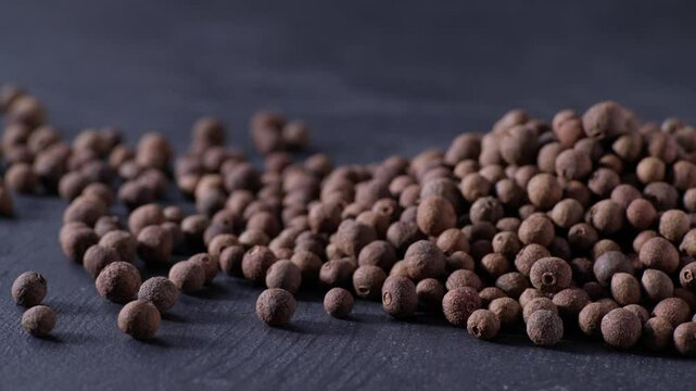 Pile allspice or Jamaican pepper on a black stone table. Heap allspice or Jamaican pepper on a black kitchen table.