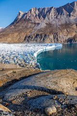 The terminus of Hisinger glacier, Dickson fjord, Northeast Greenland National Park. This is part of the Greenland Ice Sheet, and shows the mountains, moraine, glacial ice with reflection © Rixie