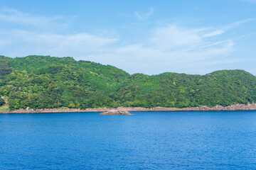 青い海と緑の山々が広がる夏の風景