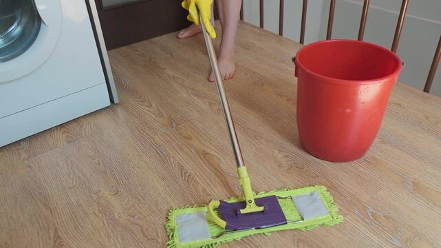 A cleaning woman thoroughly mops the floors. Surface cleaning helps reduce allergens like pollen, pet hair, and mold.