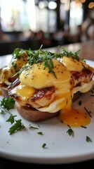 Delicious Eggs Benedict with Chicken and Fresh Herbs on Plate