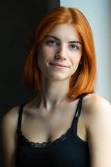 Naklejka premium Cute red-haired girl, studio portrait on a black background.