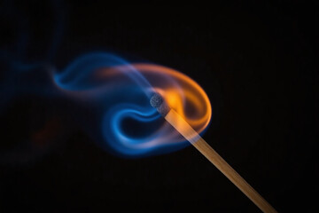 burning matchstick on black background