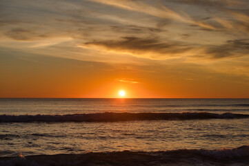 The sun reflecting on the sea in the golden hour in the atlantic ocean in Cadiz, Spain. Reflection of golden sunlight on the water. Sunset view of the sea with bright sunlight.