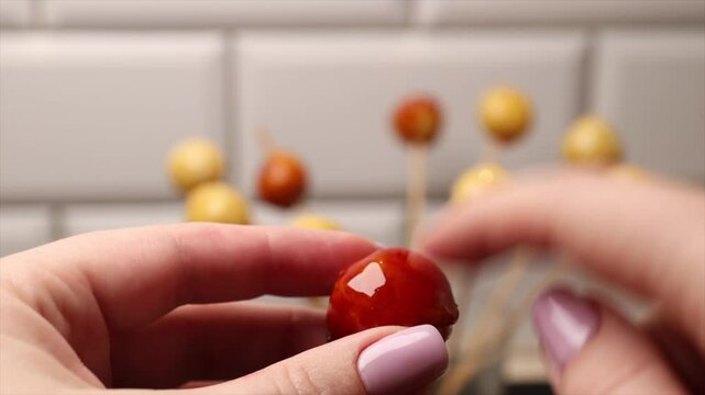 Breaking coconut balls of Brazilian dessert bala baiana. Traditional caramelized coconut treat.