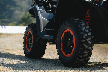 A close-up of rugged off-road tires on a black vehicle, highlighting their aggressive tread design...
