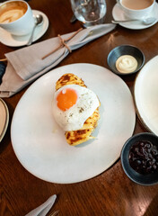 A fried sunny-side-up egg topped with black pepper sits beautifully on melted cheese toast, served on a white plate. Perfect for promoting breakfast menus, cafes, or food blogs.