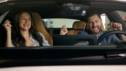Happy dancing funny moving to music radio technology audio stereo system inside car Caucasian couple in auto dance woman girl female girlfriend with man guy male boyfriend travel joy automobile auto