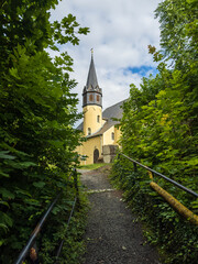 Naklejka premium Small castle nestled in picturesque German countryside. Historic architecture surrounded by lush greenery creates fairy tale atmosphere. 